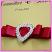Closeup of our stunning dual layer heart diamante buckle on red satin ribbons make this wedding invitation really pop!